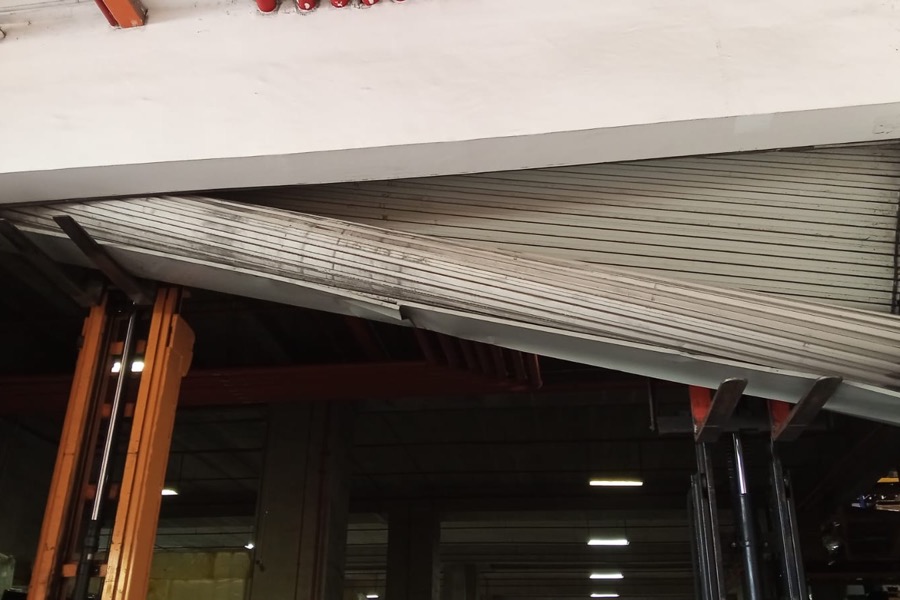 Collapsed roller shutter requiring repair at an industrial unit