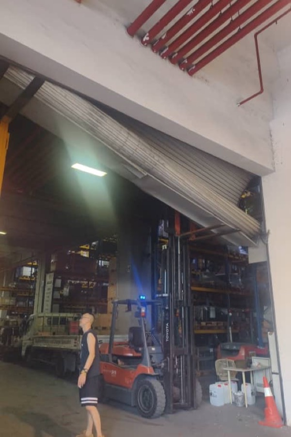 Collapsed industrial roller shutter requiring maintenance assessment