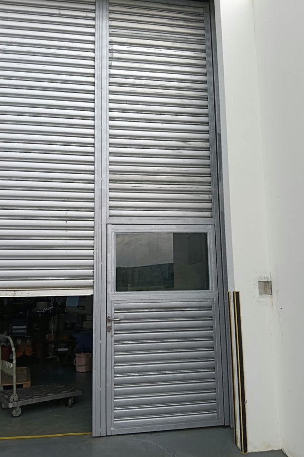 Industrial roller shutter with integrated pedestrian access door
