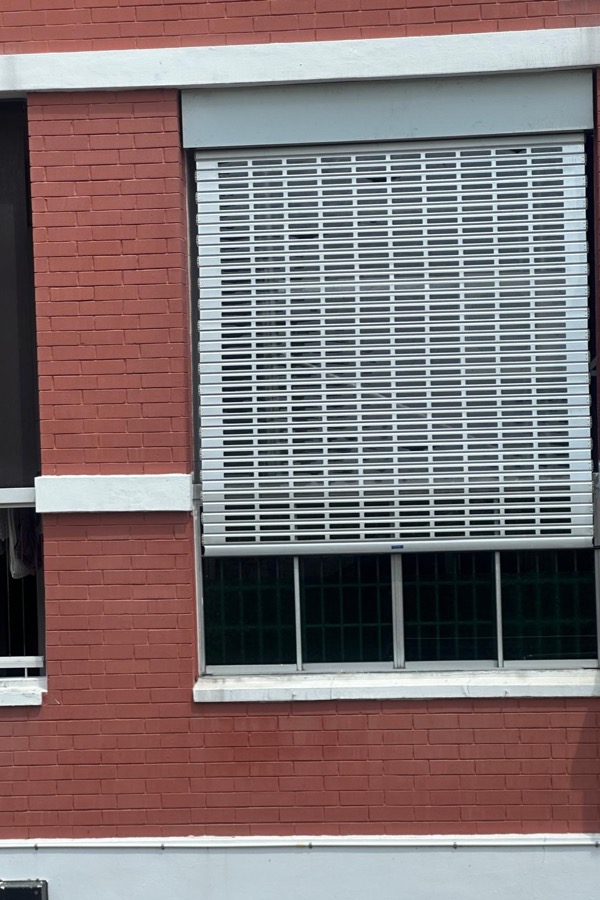 Perforated roller shutter fitted to a building opening
