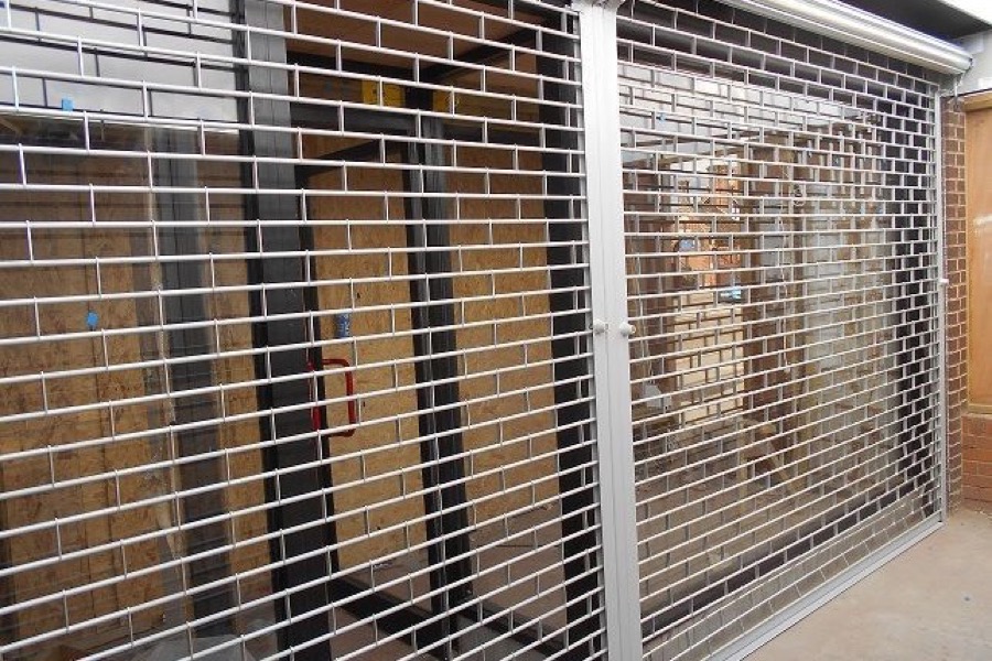 Twin roller grille shutters for commercial premises